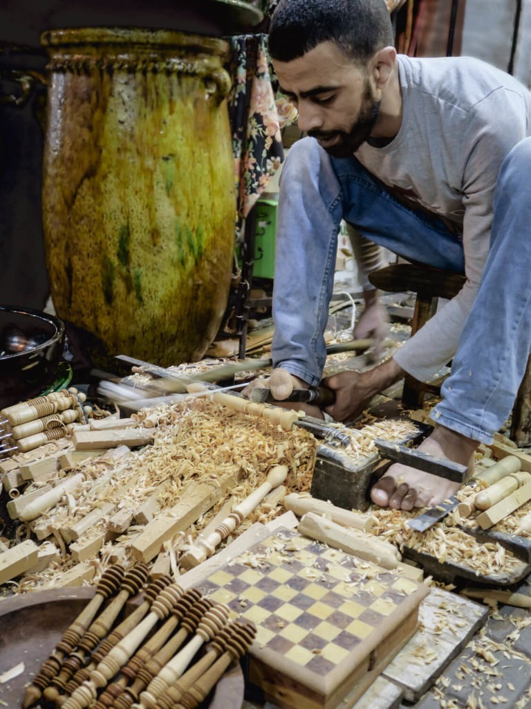 Artisan des souks de Marrakech qui travaille le bois