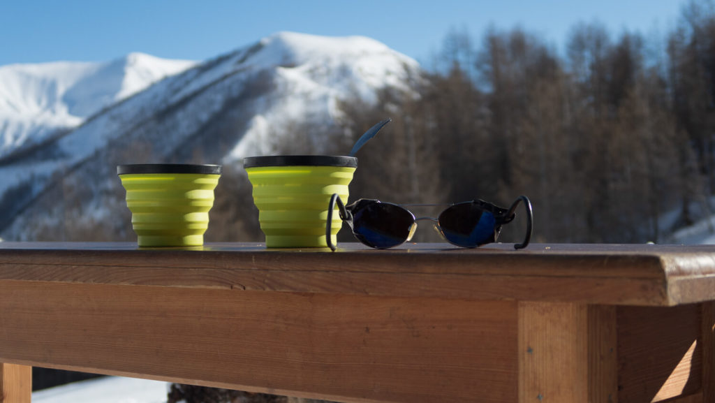 Bols de petit déjeuner sur un banc en bois avec lunettes de montagne
