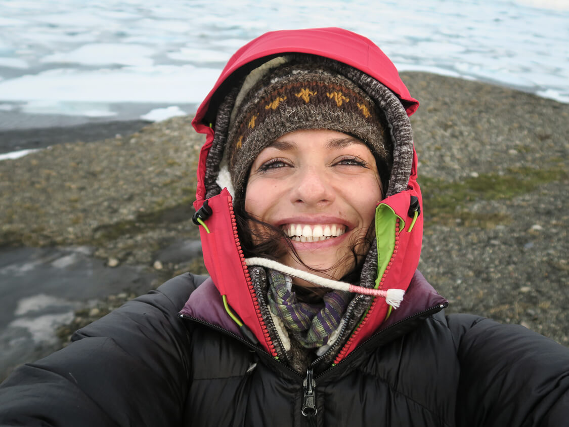 Femme souriant en autoportrait devant une mer gelée, en Islande