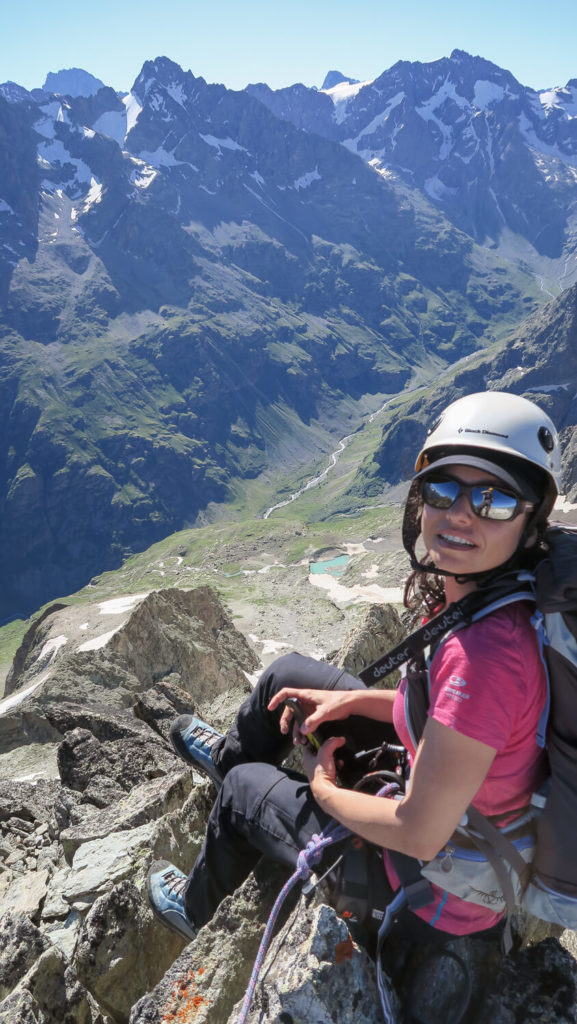 Femme avec casque en tenue d'alpinisme au sommet du Bec de Canard, vallée de la Lavey