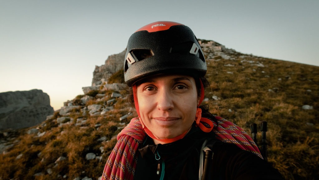 Portrait de femme avec casque d'escalade et corde sur les épaule au sommet du Mont Aiguille