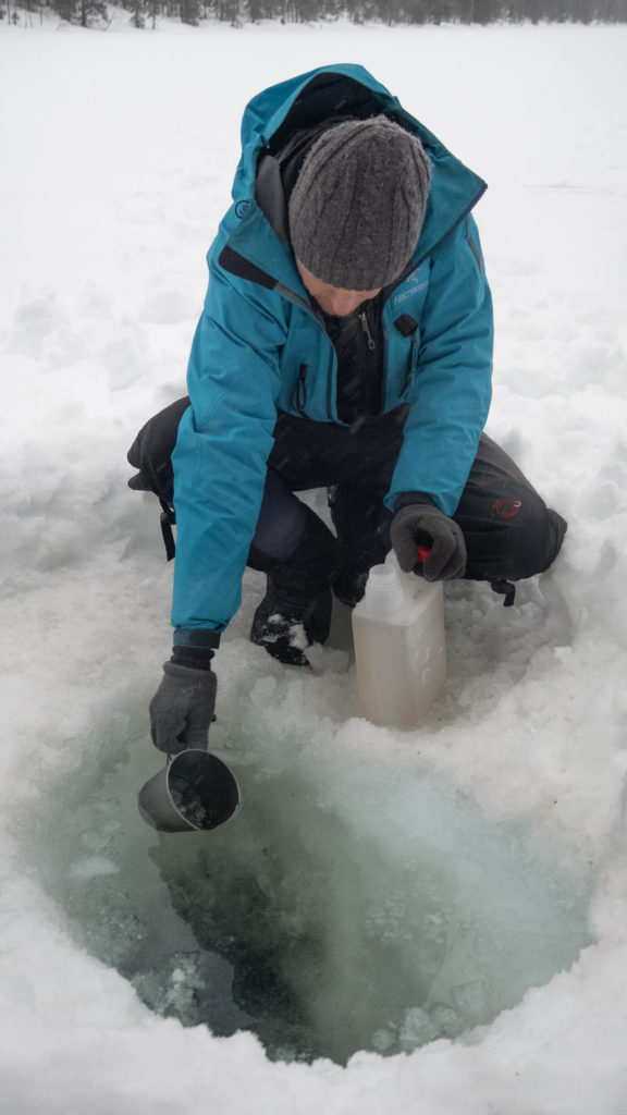 Puisage d'eau à travers un trou dans le lac gelé