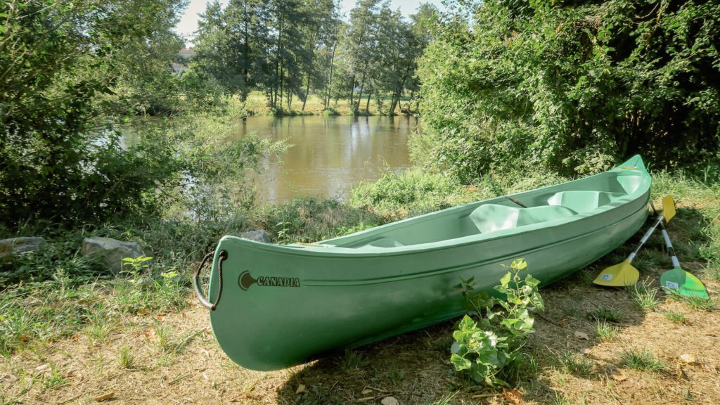 canoë vert posé sur l'herbe la rive de l'Allier avec pagaies