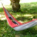 Je fais la sieste avec un chapeau sur le nez, dans un hamac tendu entre deux gros arbre sur un pré d'herbe verte