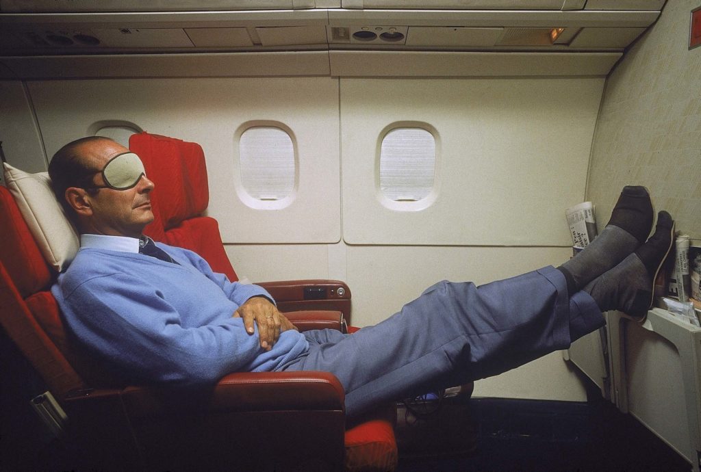 Jacques Chirac en pantoufles et masque sur les yeux, se reposant lors d'une sieste à bord du Concorde l'emmenant en Nouvelle-Calédonie.