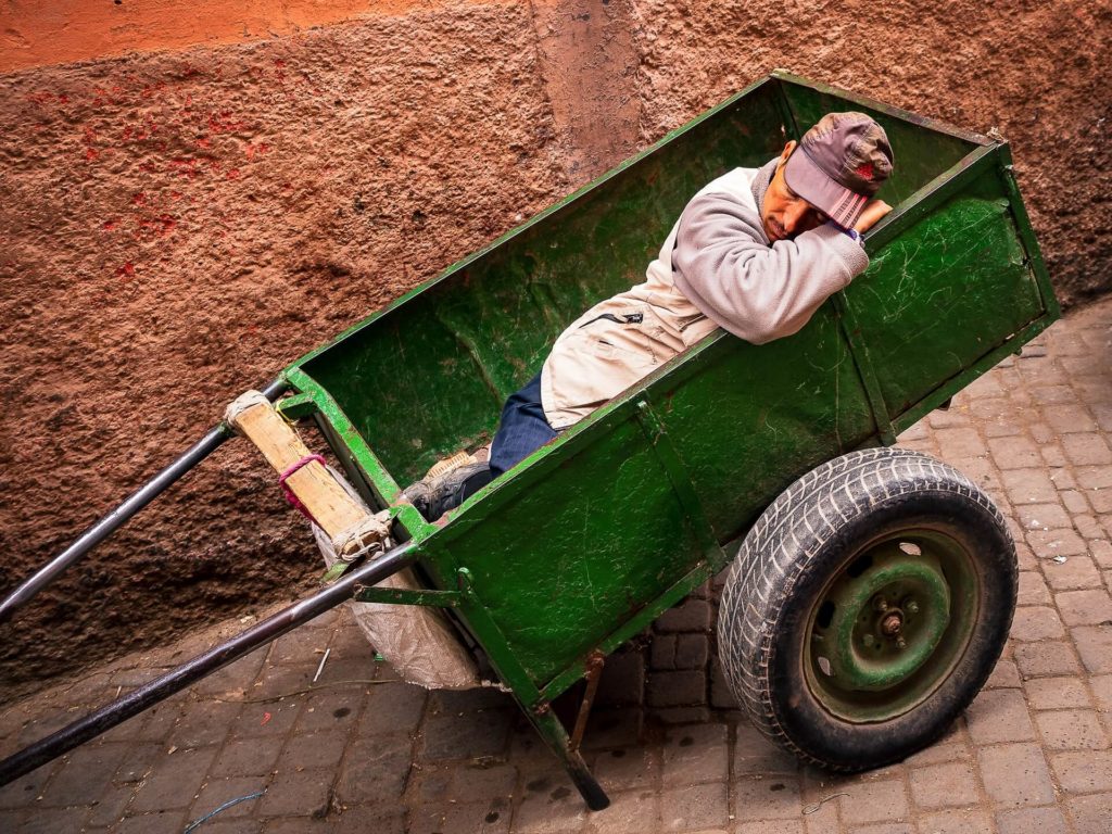 Un homme marocain fait la sieste dans une charette à Marrakech