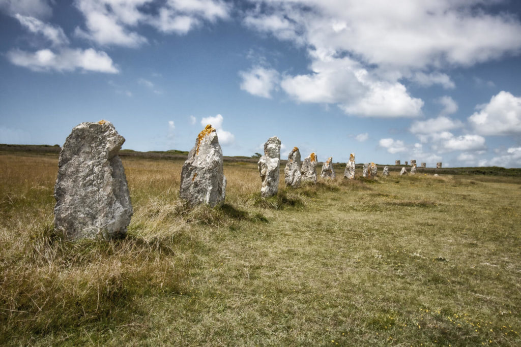 Alignements de menhirs dits de Lagatjar à Camaret-sur-Mer, dans un champ sous un ciel de nuages blancs