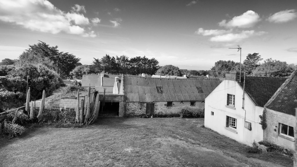 Photographie en noir et blanc d'un groupe de maisons traditionnelles bretonnes
