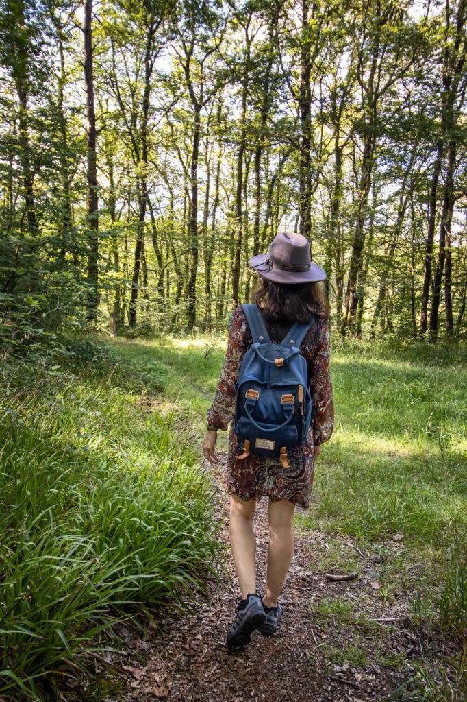 Femme avec chapeau marchant dans la forêt d'Huelgoat