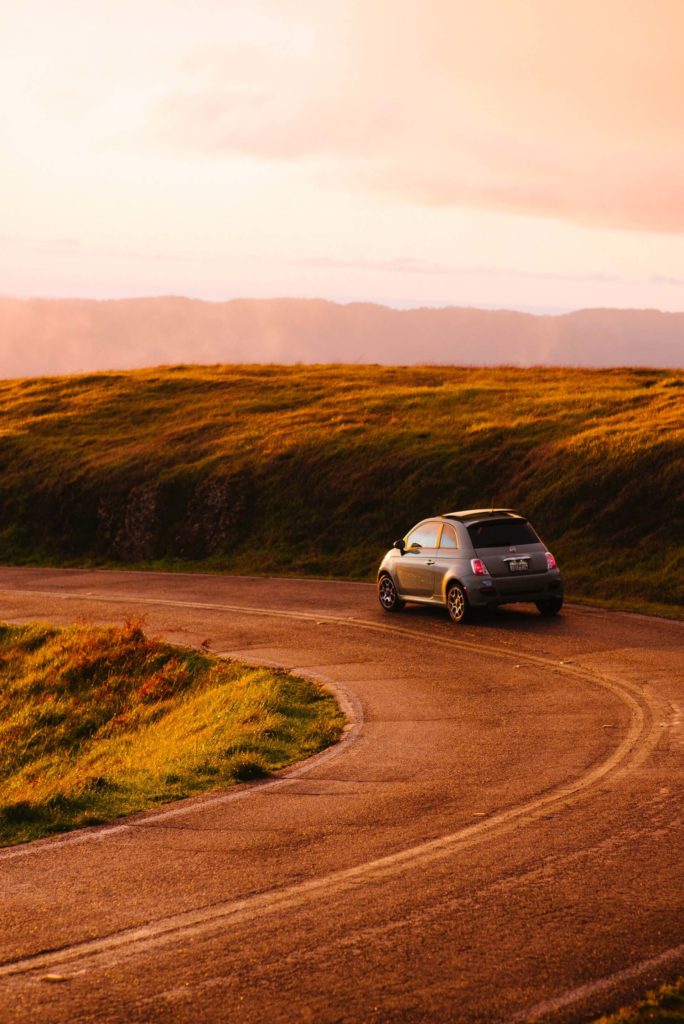Fiat 500 roulant sur une route au coucher du soleil