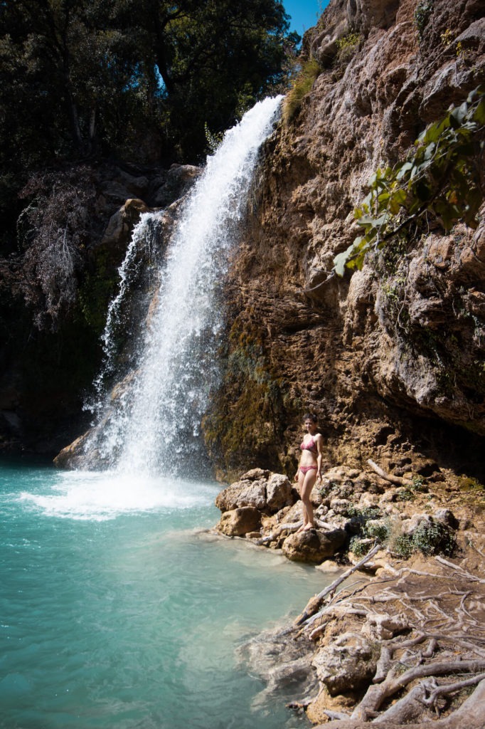Femme en maillot de bain au bord de la petite cascade de Sillans