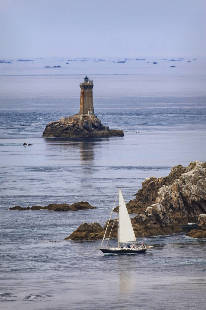 Voilier à la pointe du raz avec le phare de La Vieille en fond