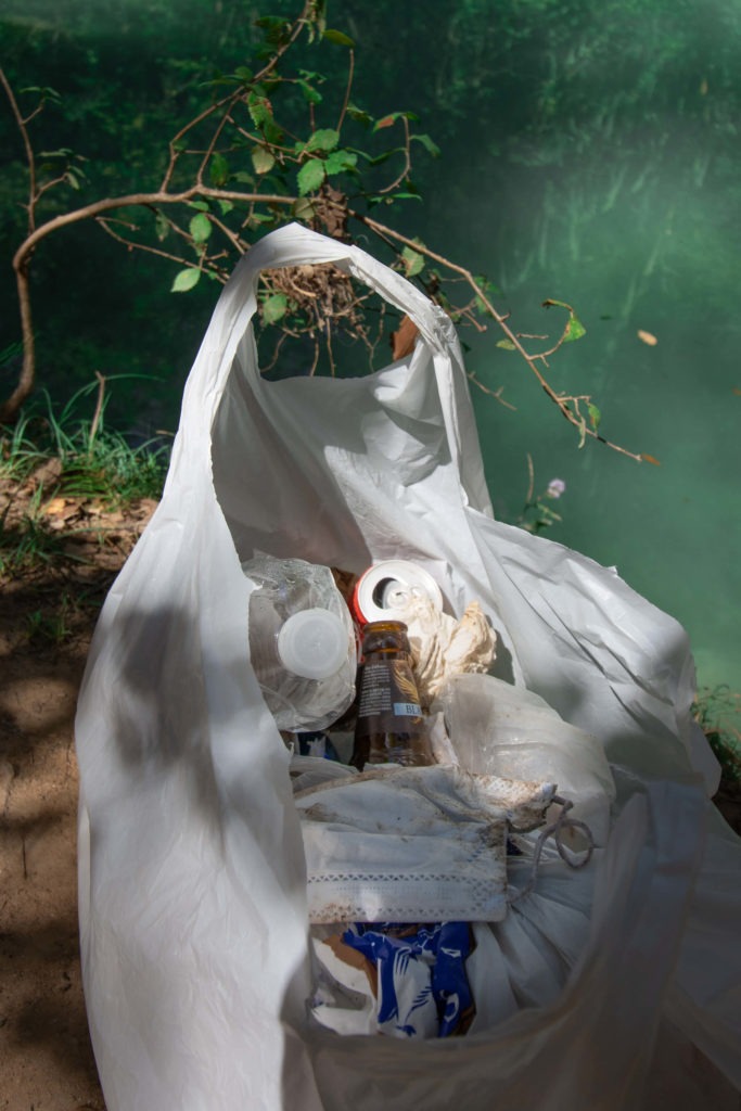 Sac plastique contenant des déchets ramassés près de la cascade de Sillans