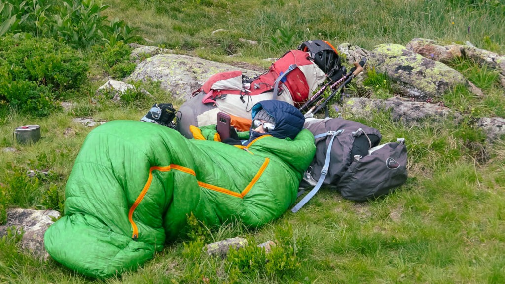 Je suis emmitouflée dans mon duvet avec ma doudoune, allongée dans l'herbe
