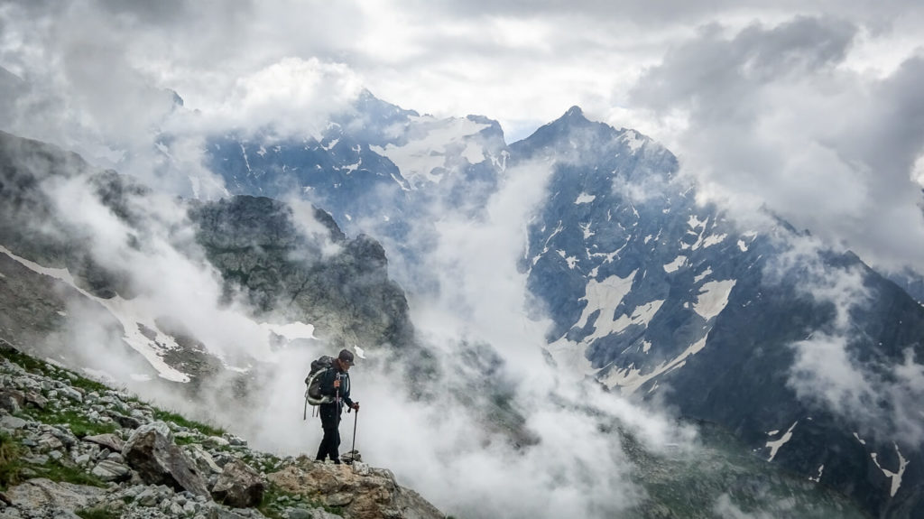 Marcheuse en montagne dans les nuages, avec bâtons de marche